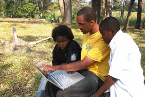 My son Sekani Tembo who was a Third year computer major in at an American College showing his cousins, Abiudi and Nina, a lap top computer behind the Castle Hotel in Lundazi in 2009.